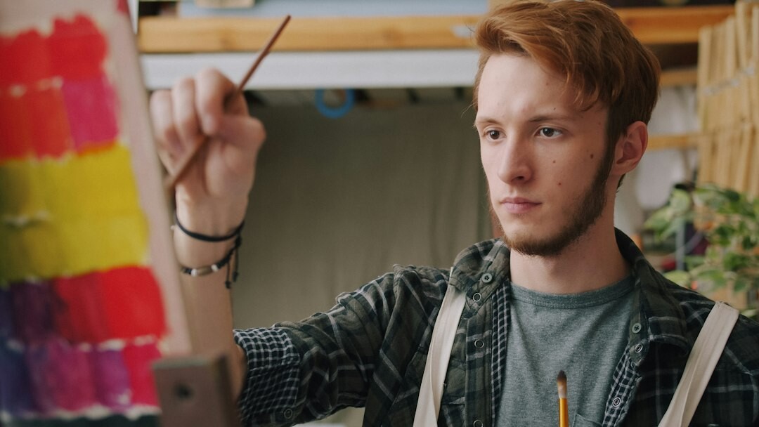 Young man editing video footage on a laptop in a creative studio